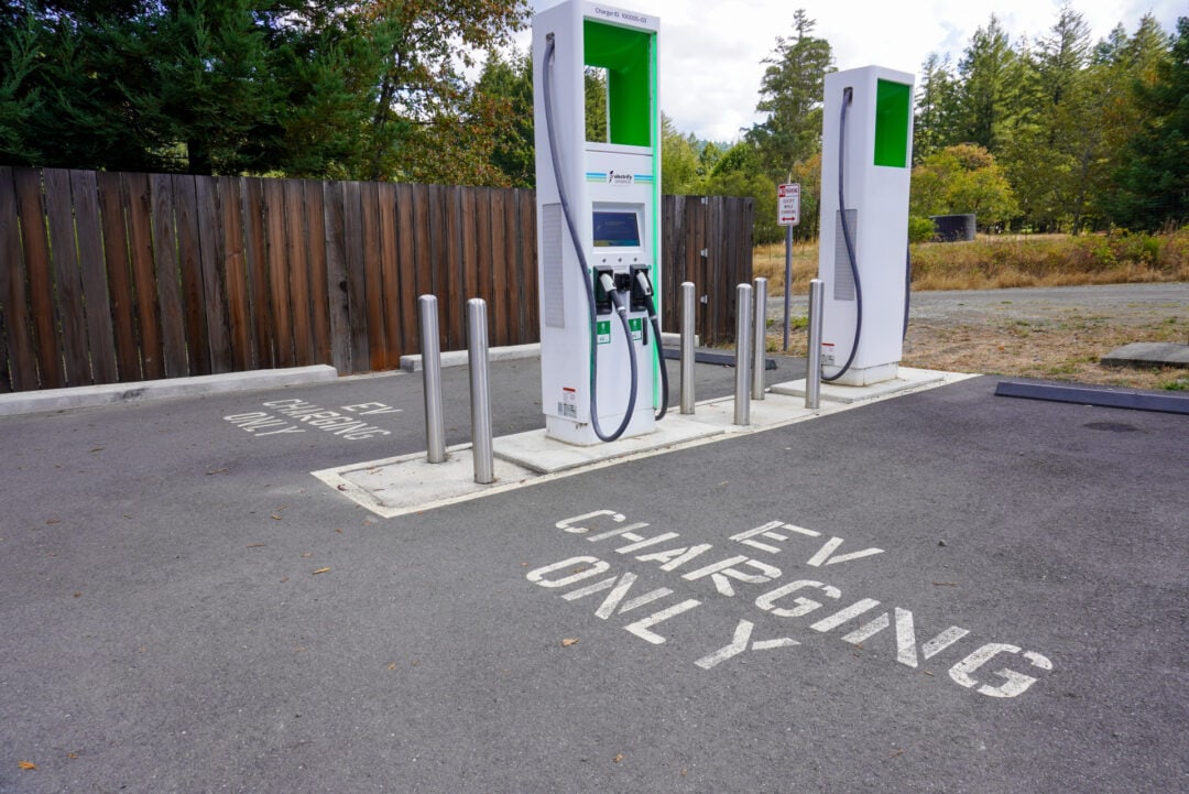 Two EV charging stations next to two designated EV charging parking spots