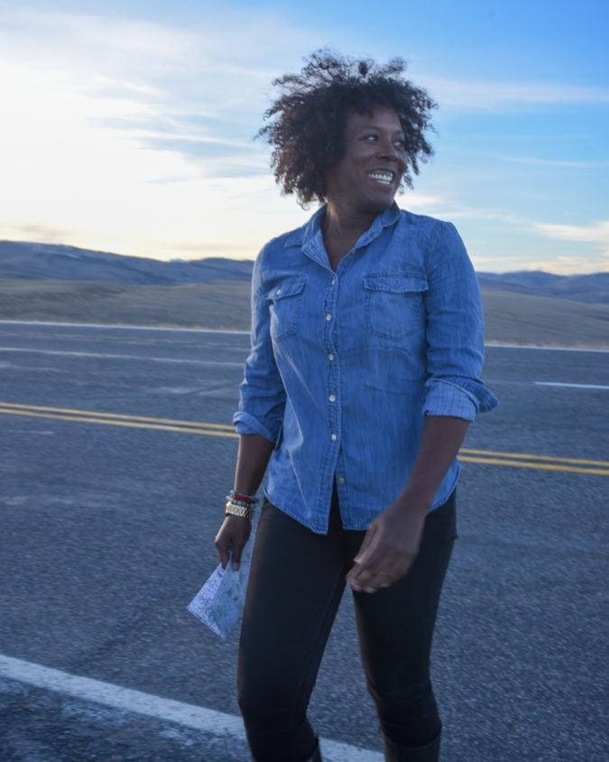a woman stands and smiles on a road