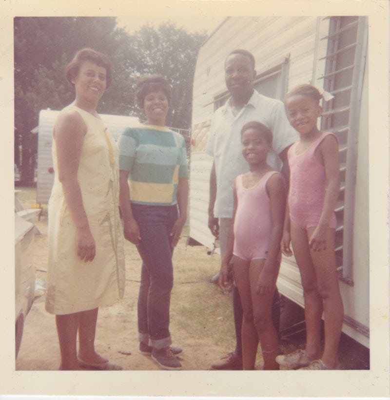 a family of five smiles at the camera