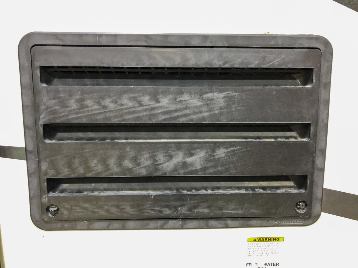 Closup of an exterior fridge access panel cover on an RV