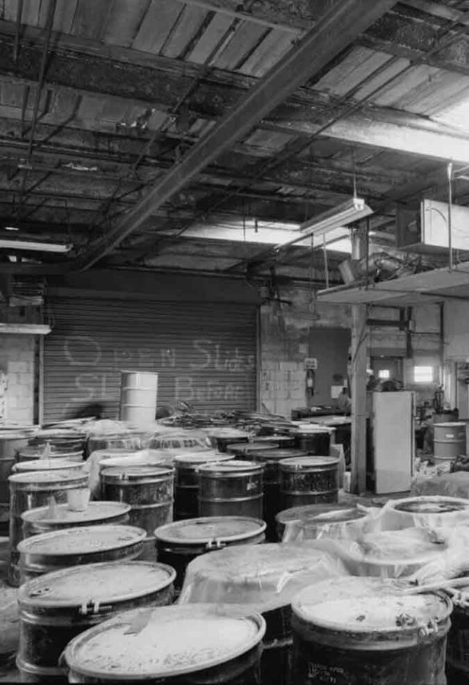 the inside of a chemical storage facility with barrels of chemicals