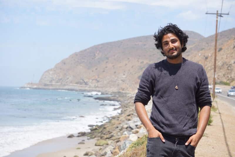 The author stands in front of a large body of water